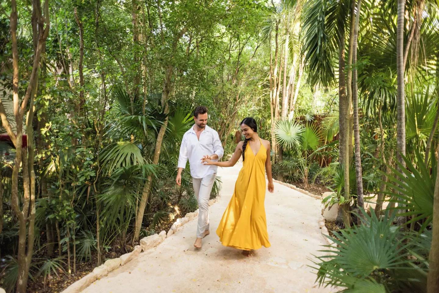 Couple walking on a lush garden path at Viceroy Riviera Maya.