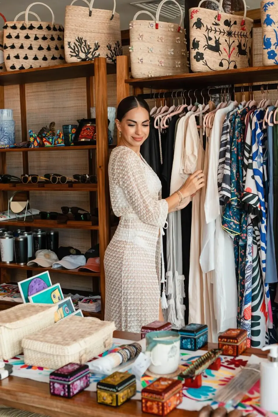 A guest browses clothing and woven bags in a boutique at Viceroy Riviera Maya.
