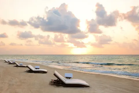 Beach loungers face the sunrise over the Caribbean at Viceroy Riviera Maya.