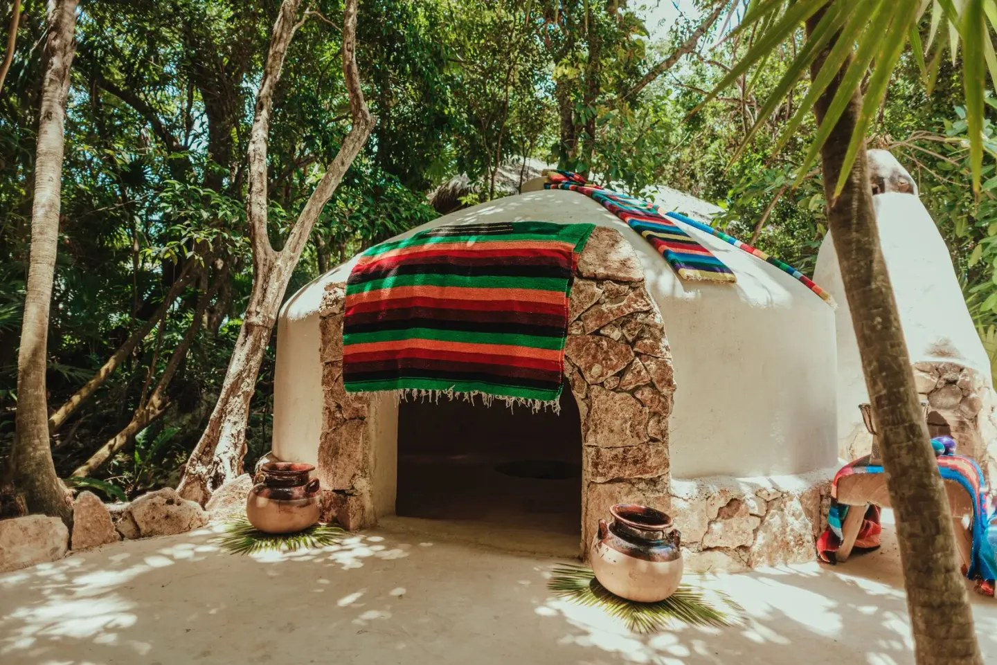 Domed temazcal structure draped with colorful textiles at Viceroy Riviera Maya.