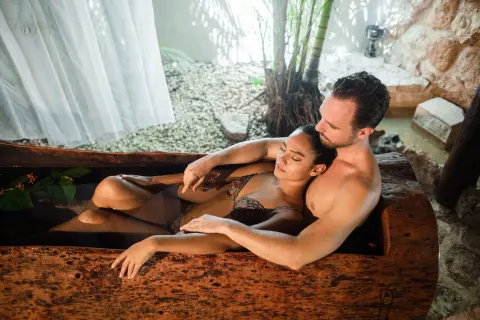 Couple soaking in a wooden spa tub at Viceroy Riviera Maya.