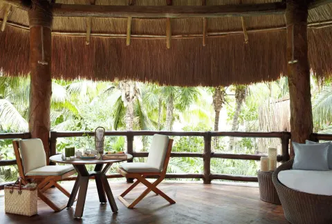 Ocean View Two Level Villa terrace seating among palms at Viceroy Riviera Maya.