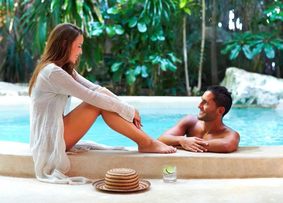 Couple relaxing by a private plunge pool surrounded by greenery at Viceroy Riviera Maya.
