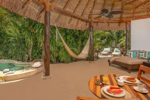 Royal Villa covered deck at Viceroy Riviera Maya with hammock, breakfast table, and plunge pool.