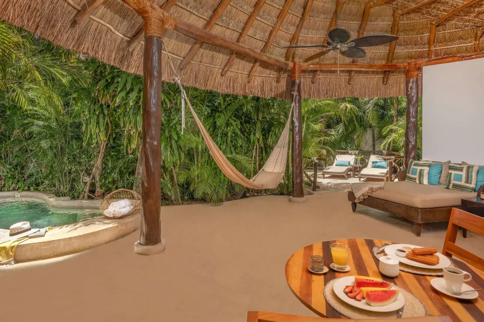 Royal Villa covered deck at Viceroy Riviera Maya with hammock, breakfast table, and plunge pool.