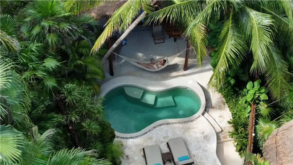 Overhead view of the Royal Villa pool deck framed by palms at Viceroy Riviera Maya.