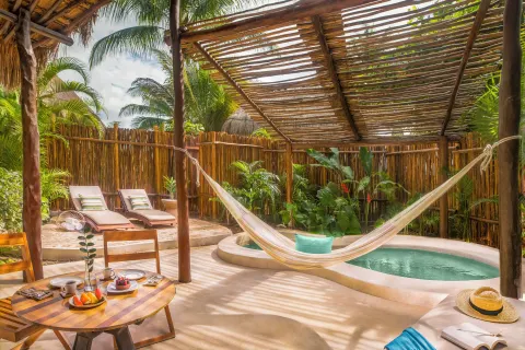 Private villa deck with hammock, plunge pool, loungers, and breakfast at Viceroy Riviera Maya.