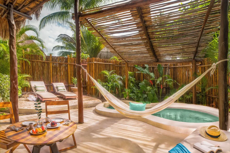 Private villa deck with hammock, plunge pool, loungers, and breakfast at Viceroy Riviera Maya.