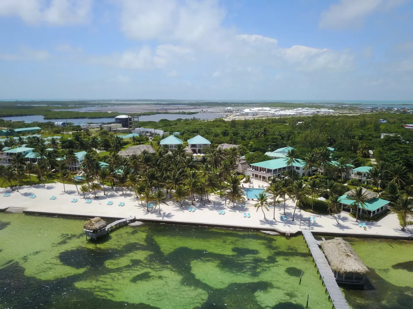 Aerial beachfront view of palms, piers, beach loungers, and turquoise water at Victoria House Resort & Spa.