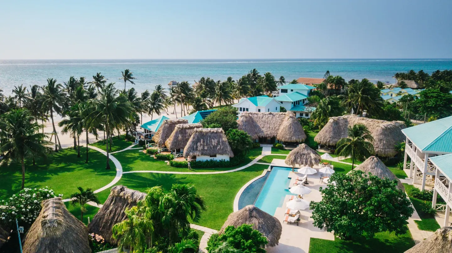 Aerial view of palms, beach, cottages, and pool at Victoria House Resort & Spa.
