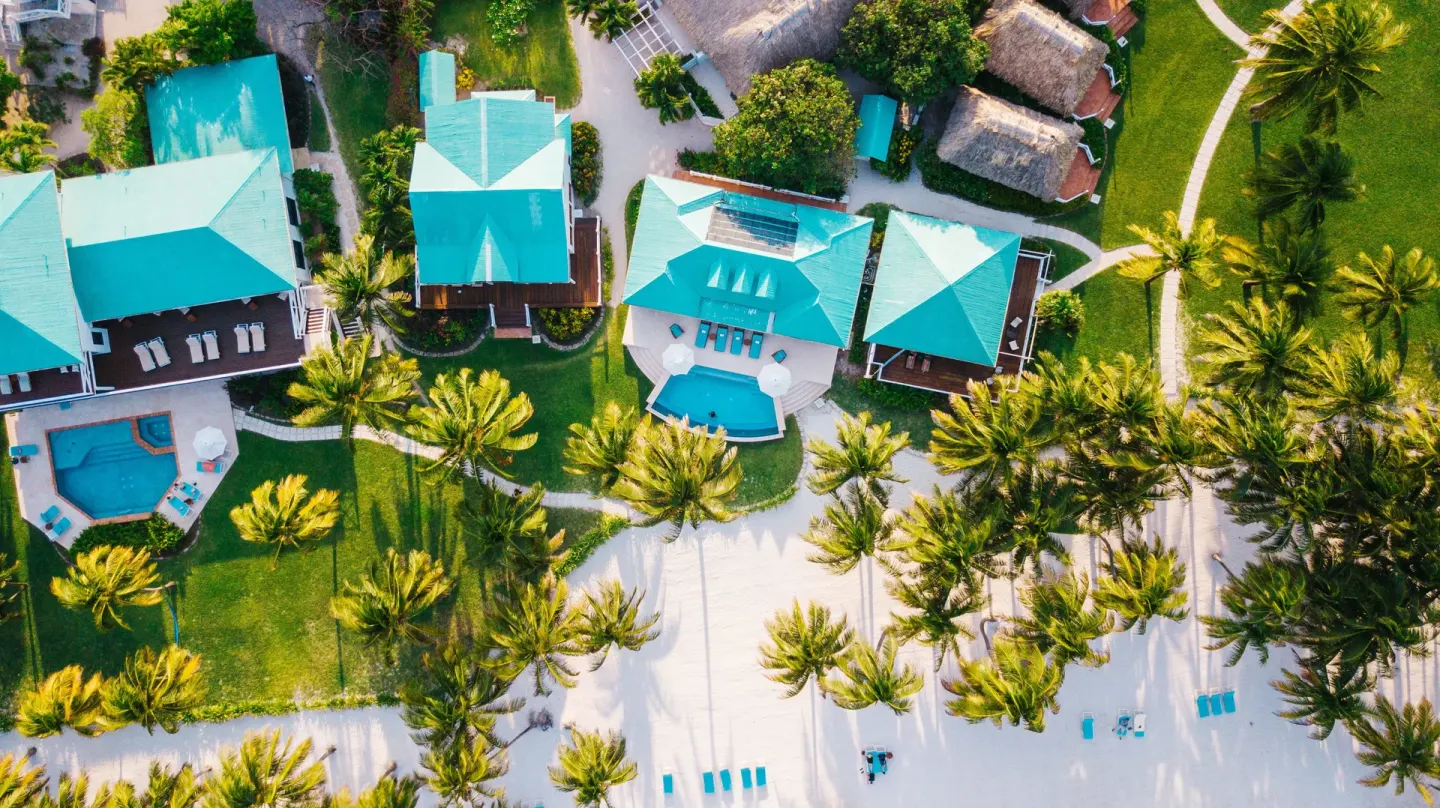 Aerial view of beachfront villas, pools, palms, and sand at Victoria House Resort & Spa.