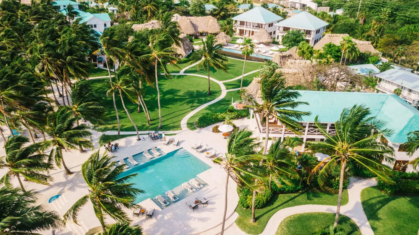 Aerial view of pool, palms, paths, and guest buildings at Victoria House Resort & Spa.