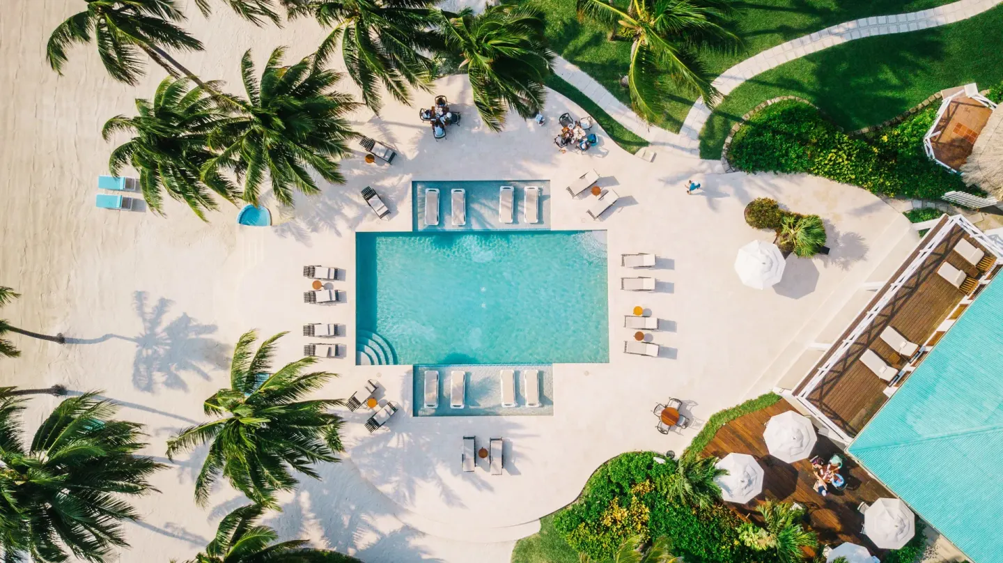 Aerial view of the main pool, loungers, palms, and patio at Victoria House Resort & Spa.