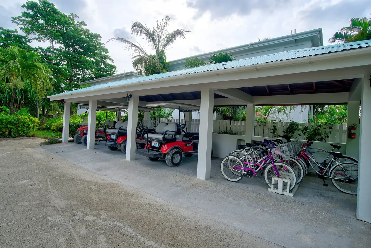 Covered golf carts and bicycles parked on resort grounds at Victoria House Resort & Spa.