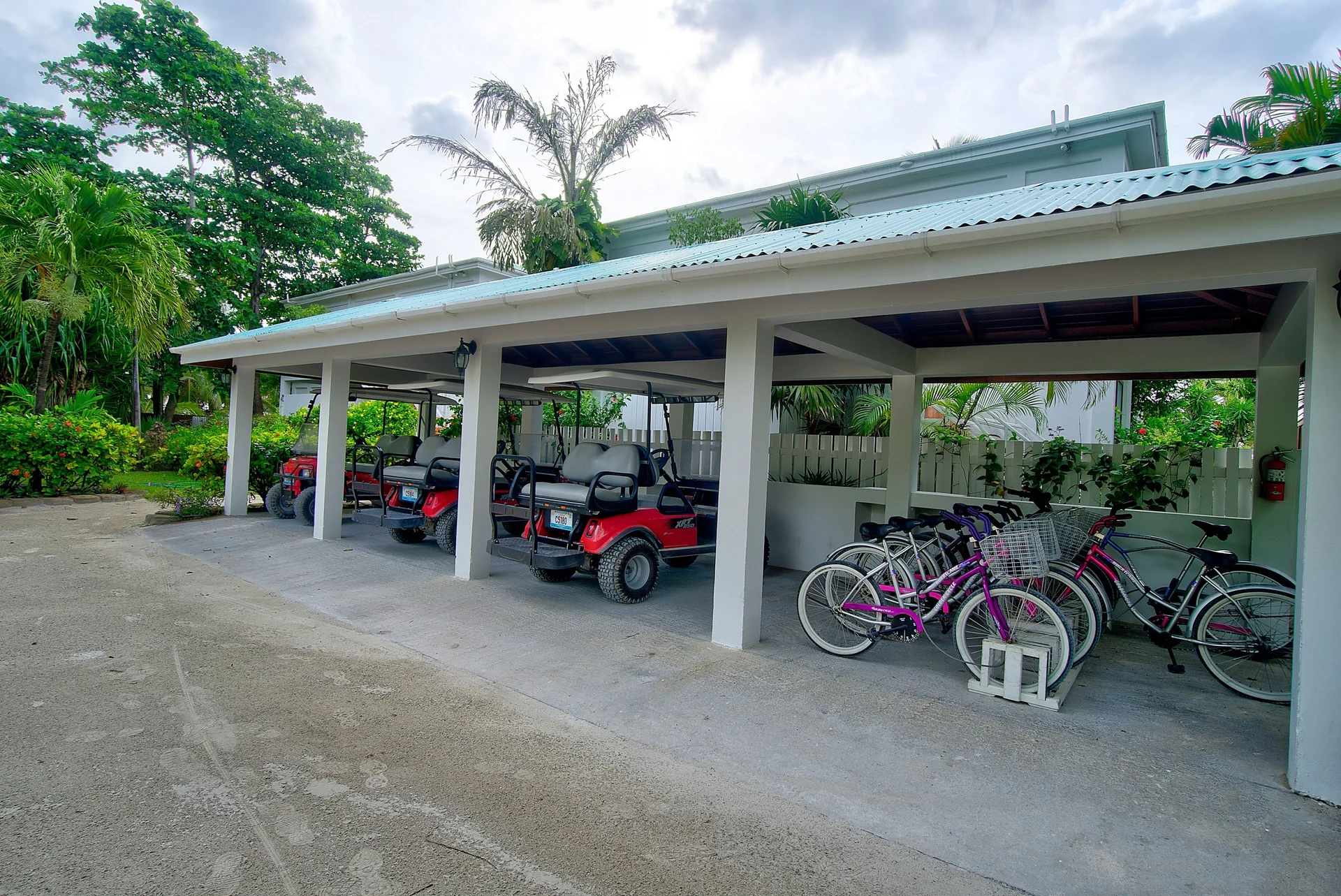 Covered golf carts and bicycles parked on resort grounds at Victoria House Resort & Spa.