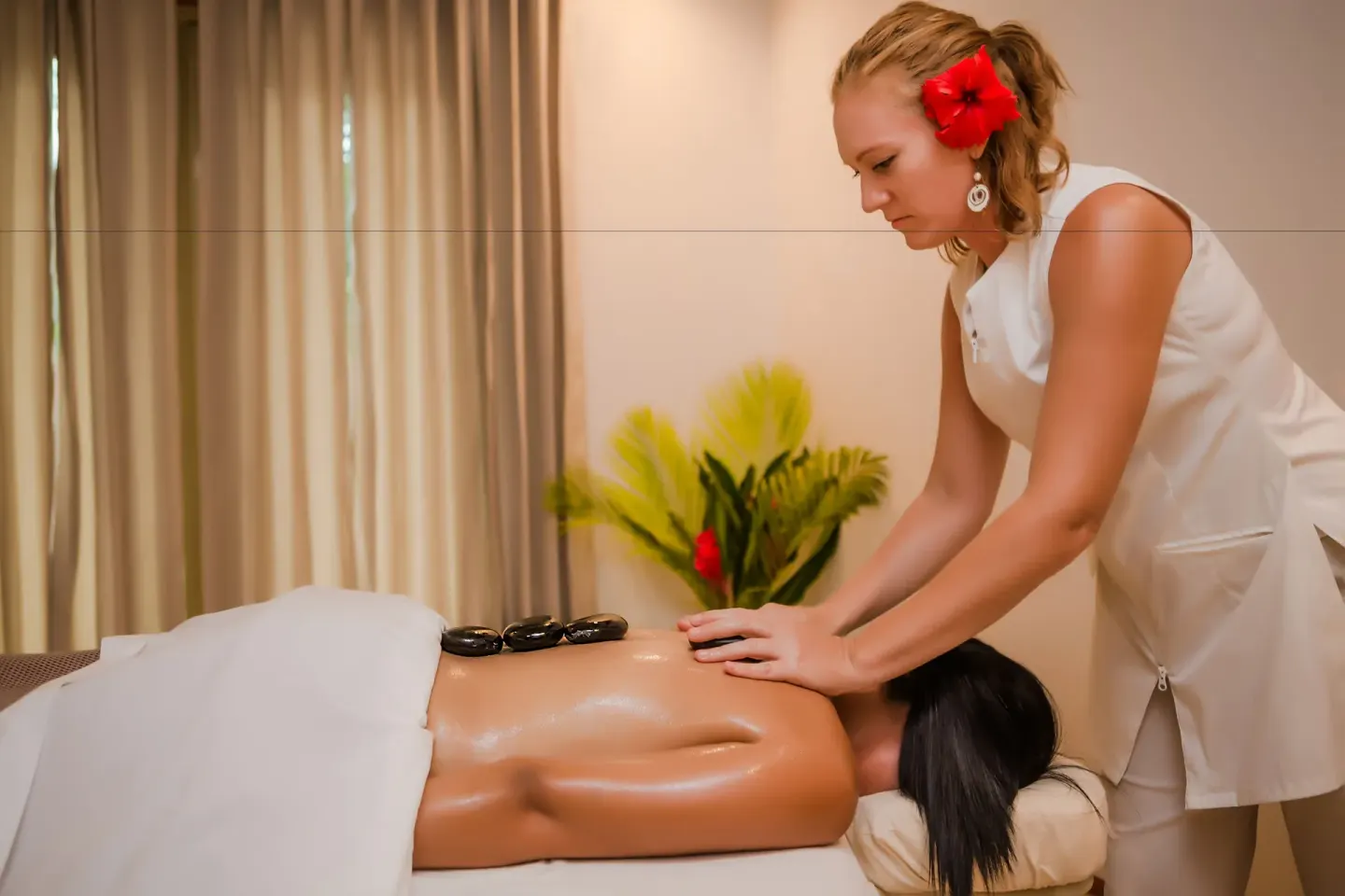 Spa therapist gives a hot stone massage at Victoria House Resort & Spa.