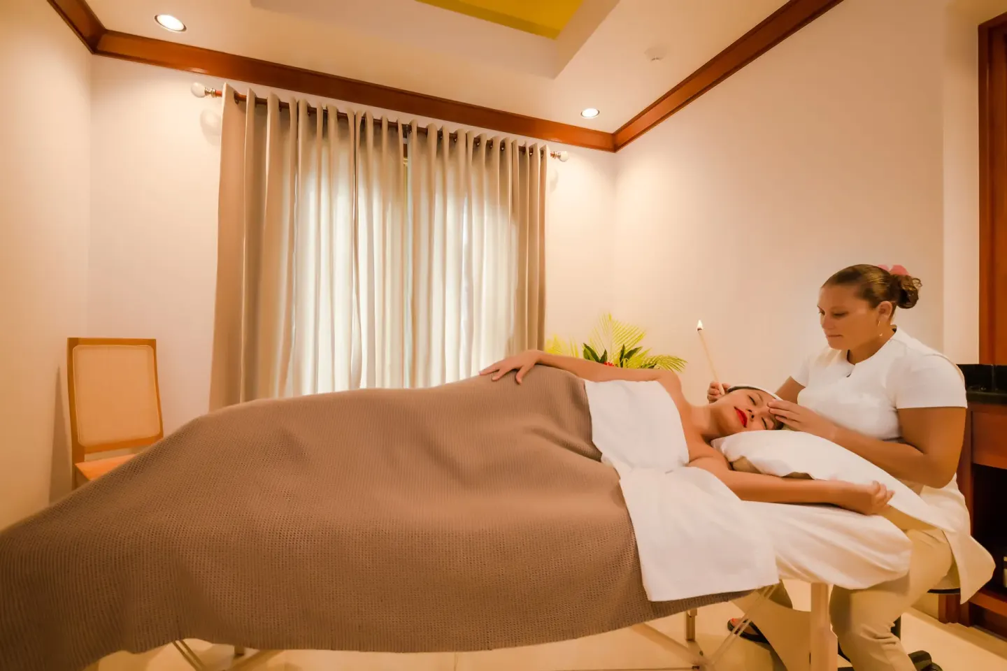 Spa therapist performing a facial treatment at Victoria House Resort & Spa.