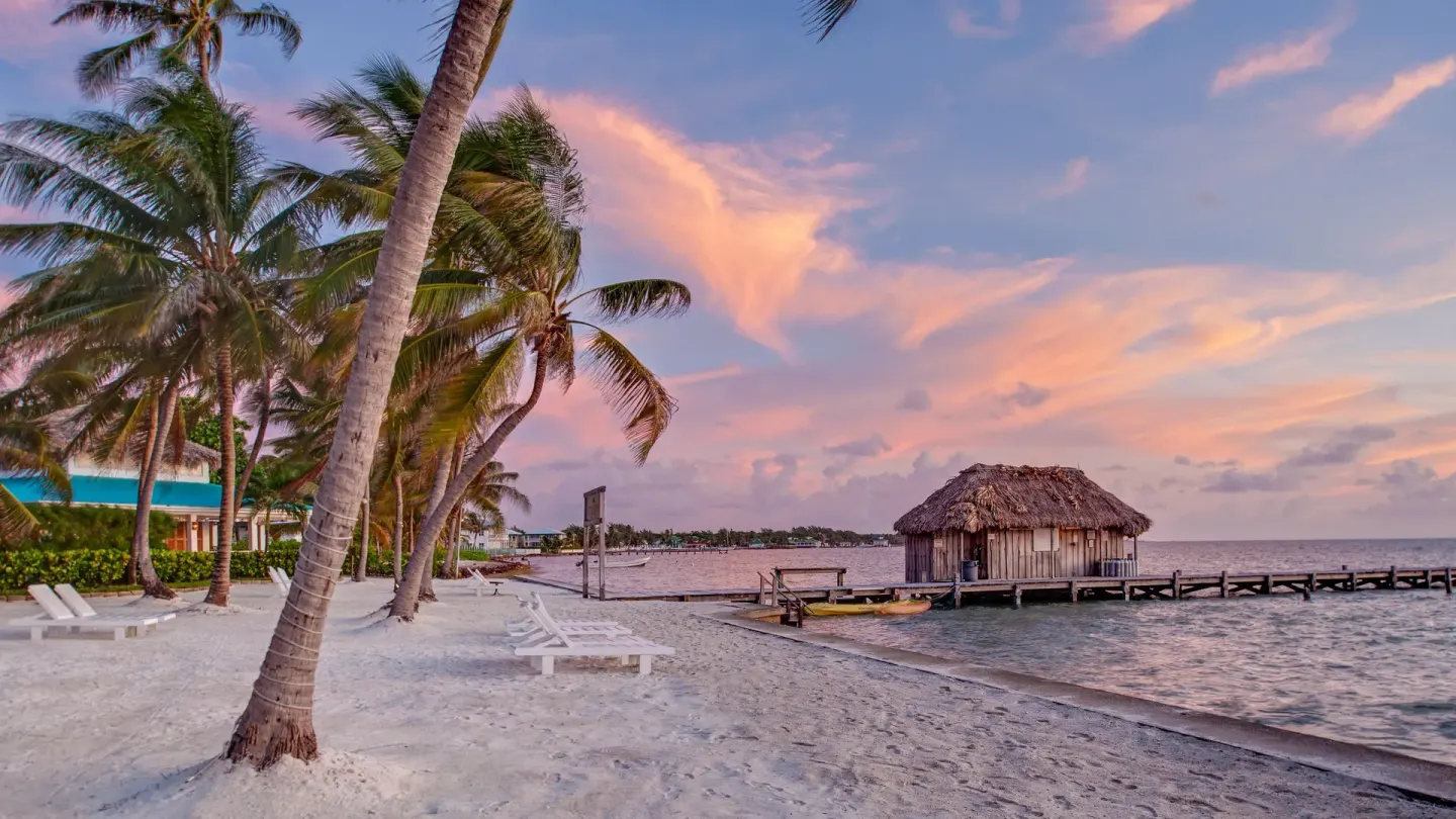 Sunset beach with palms, loungers, and pier at Victoria House Resort & Spa.