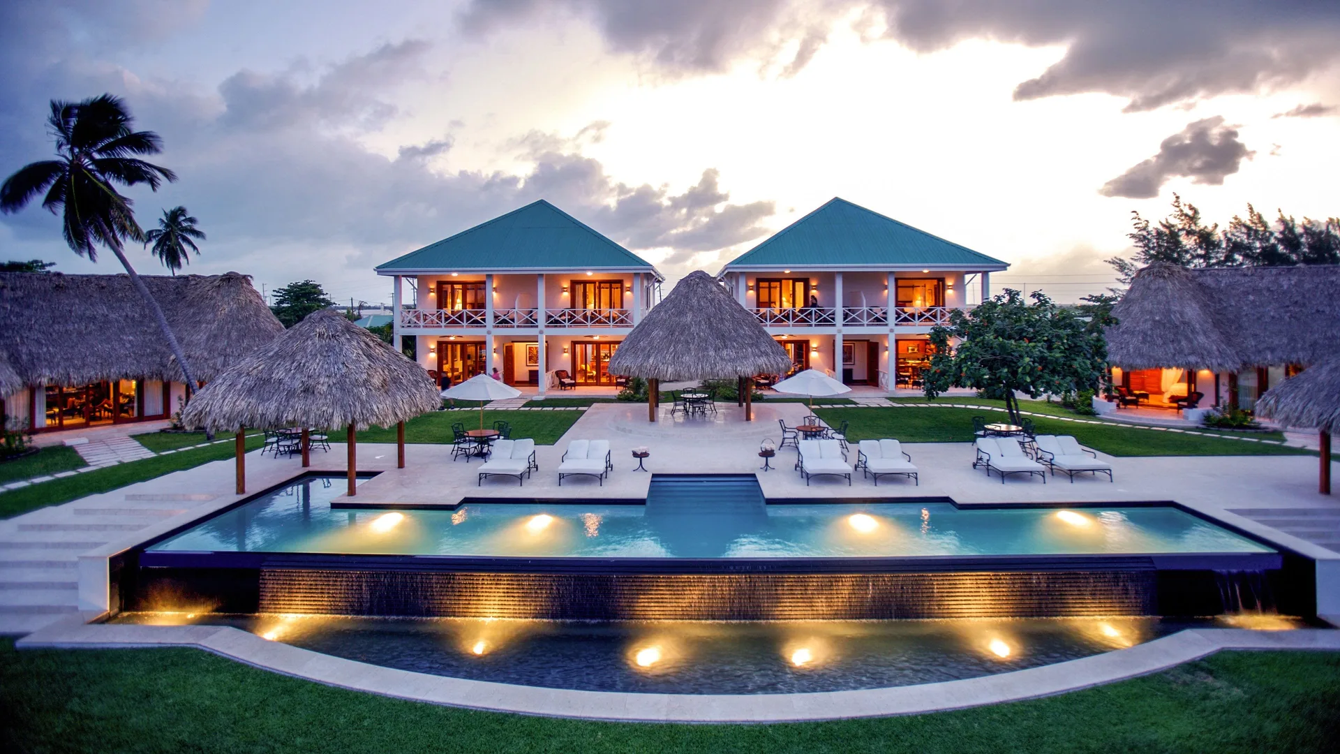 Twilight pool, palapas, and resort buildings at Victoria House Resort & Spa.