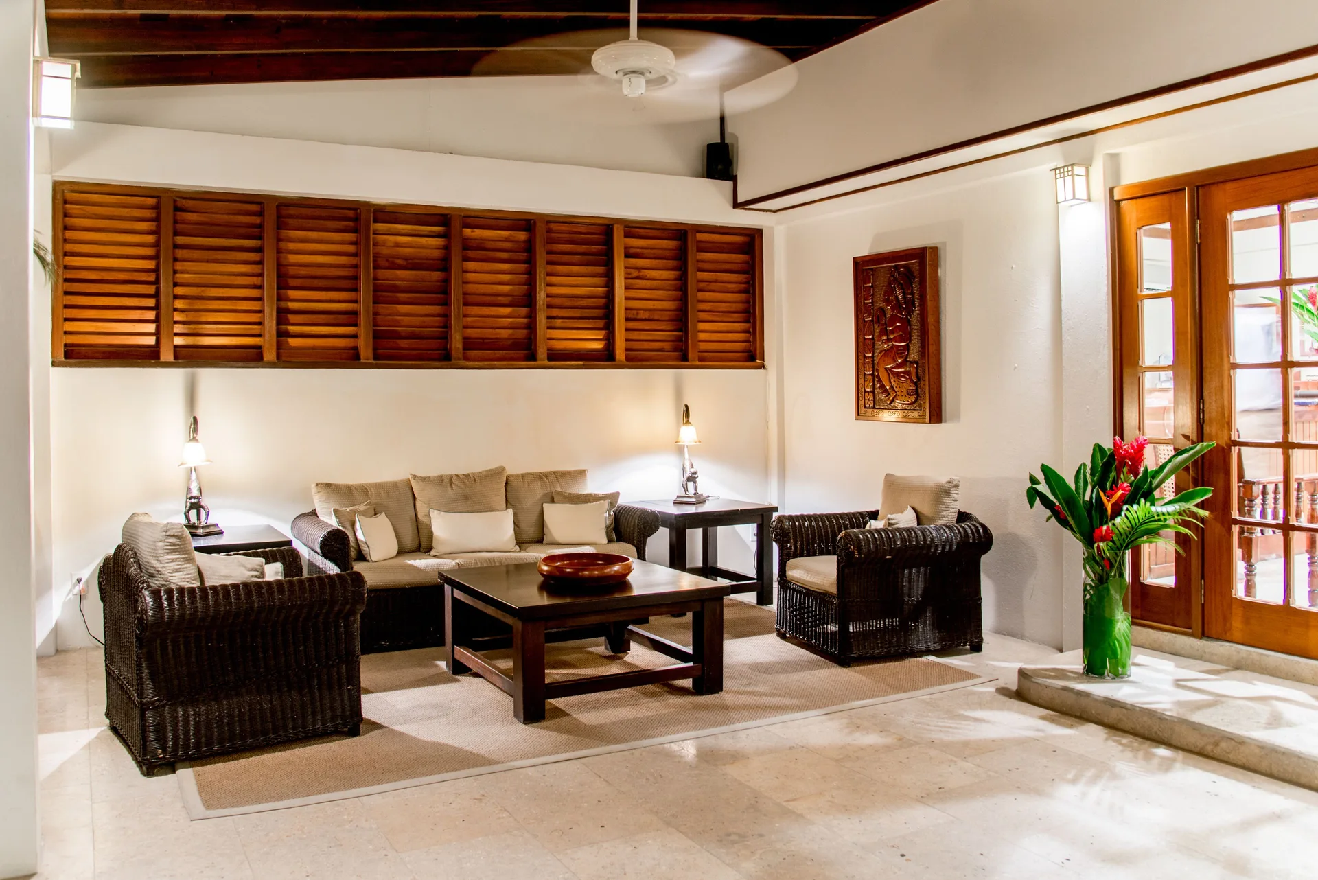 Wicker seating area with wood shutters in a lounge at Victoria House Resort & Spa.