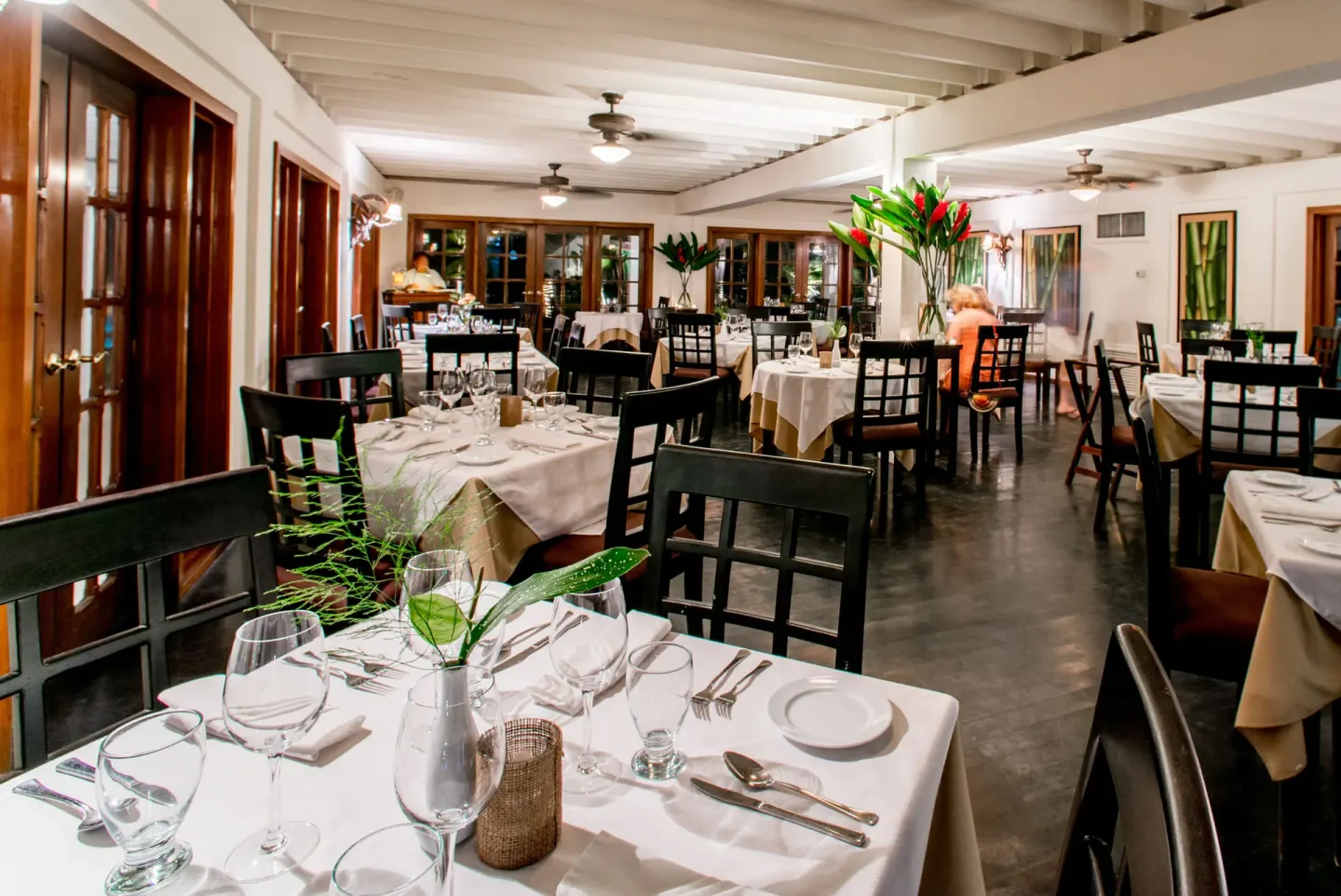 White-tablecloth dining room with dark chairs at Victoria House Resort & Spa.