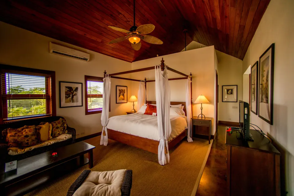 One Bedroom Infinity Suite king bed and lounge seating at Victoria House Resort & Spa.