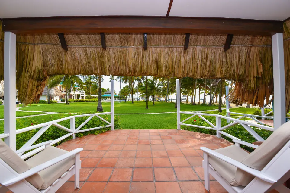 Casita veranda with white chairs facing the lawn at Victoria House Resort & Spa.