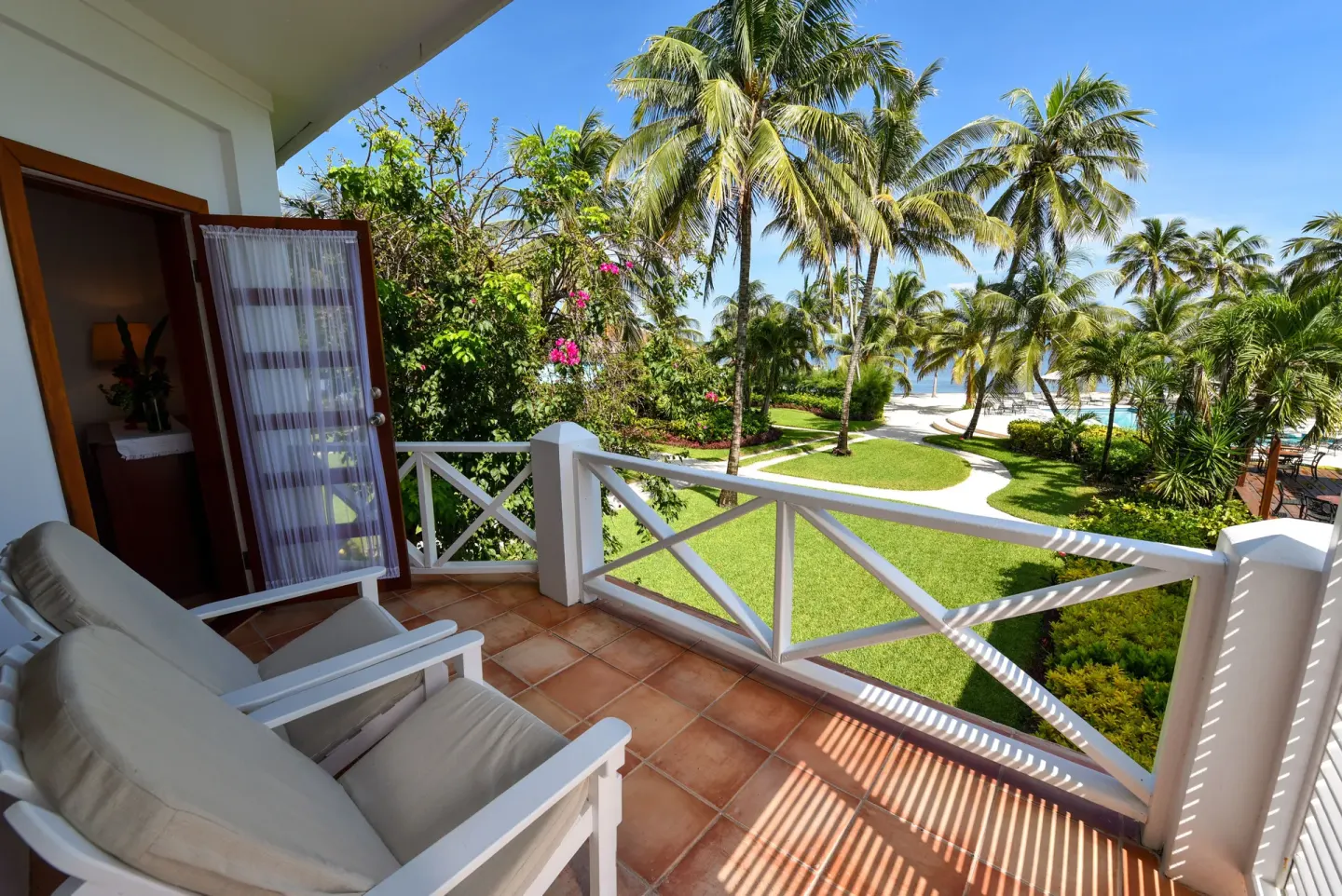Palmetto Room balcony with palm garden and sea view at Victoria House Resort & Spa.