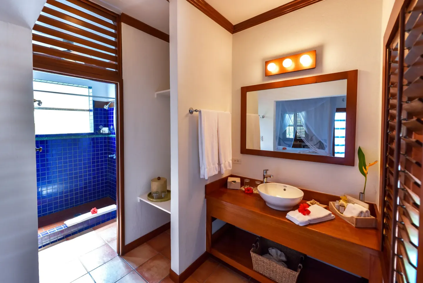 Palmetto Room bathroom vanity and blue-tiled shower at Victoria House Resort & Spa.