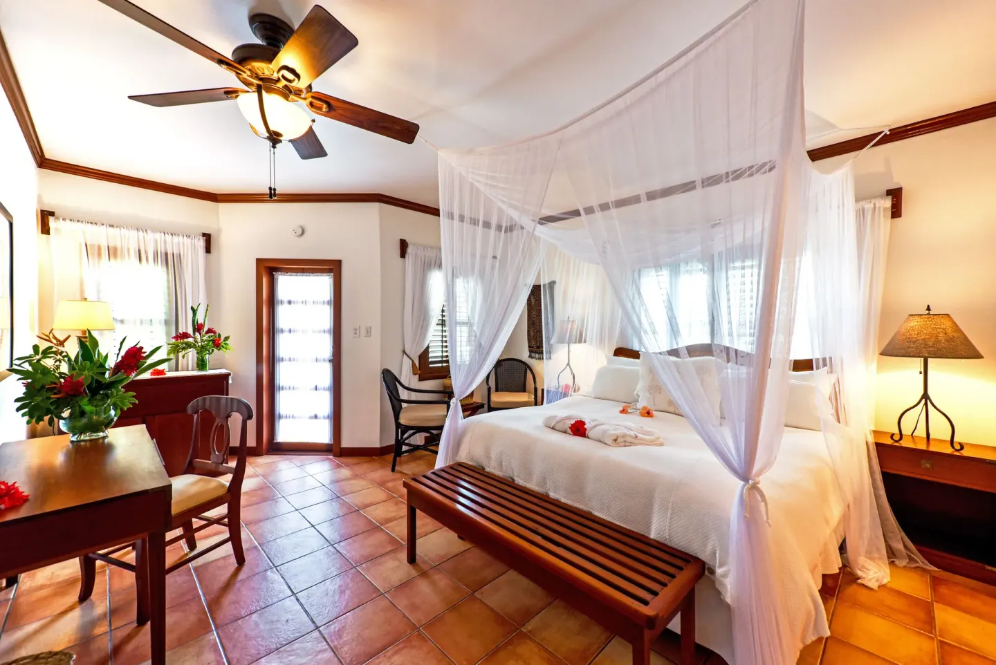 Palmetto Room canopy bed, desk, and tiled floor at Victoria House Resort & Spa.