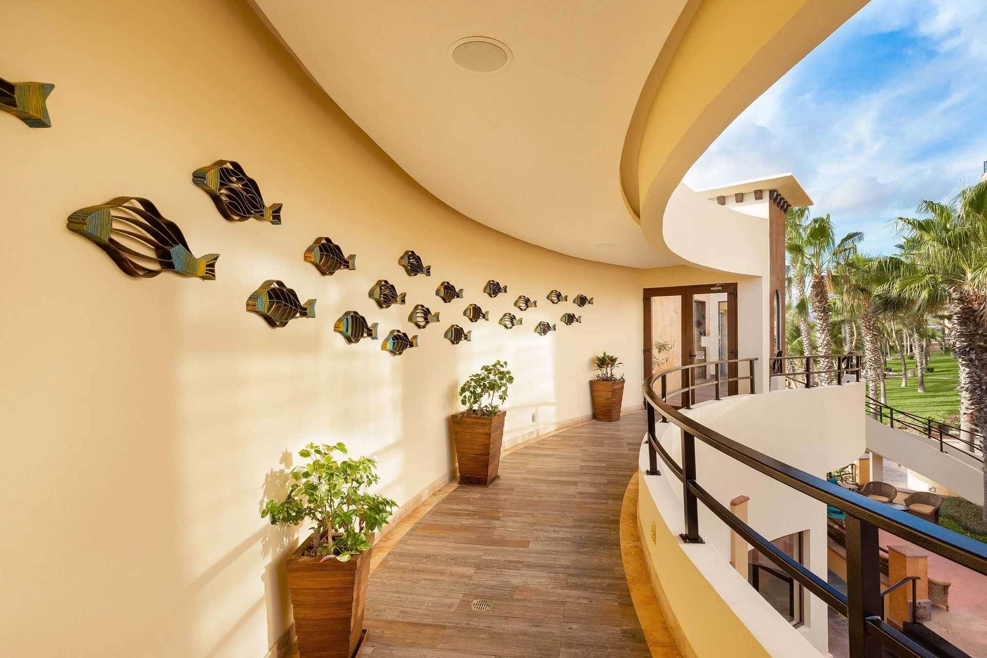 Curved corridor with fish wall art at Villa del Arco Beach Resort & Spa Cabo San Lucas.