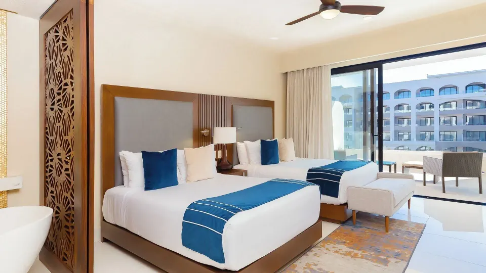 Two-bed guest room with balcony at Villa del Arco Beach Resort & Spa Cabo San Lucas.