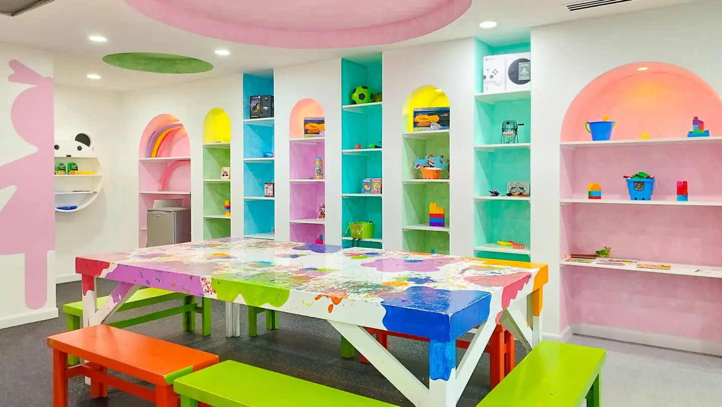 Kids craft room at Villa del Arco Beach Resort & Spa Cabo San Lucas with colorful benches and arched shelves.
