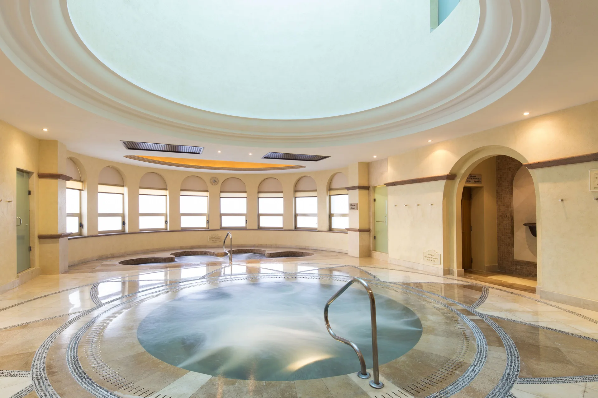 Spa hydrotherapy pool at Villa del Arco Beach Resort & Spa Cabo San Lucas with arched windows and tiled floor.