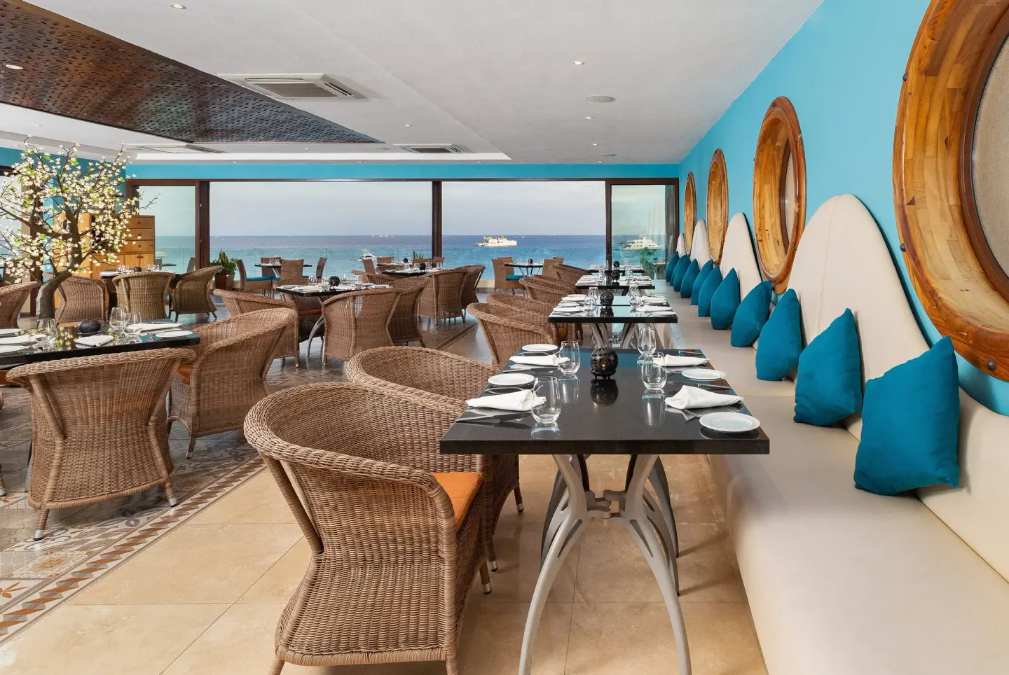 Oceanview dining room with wicker seating at Villa del Arco Beach Resort & Spa Cabo San Lucas.