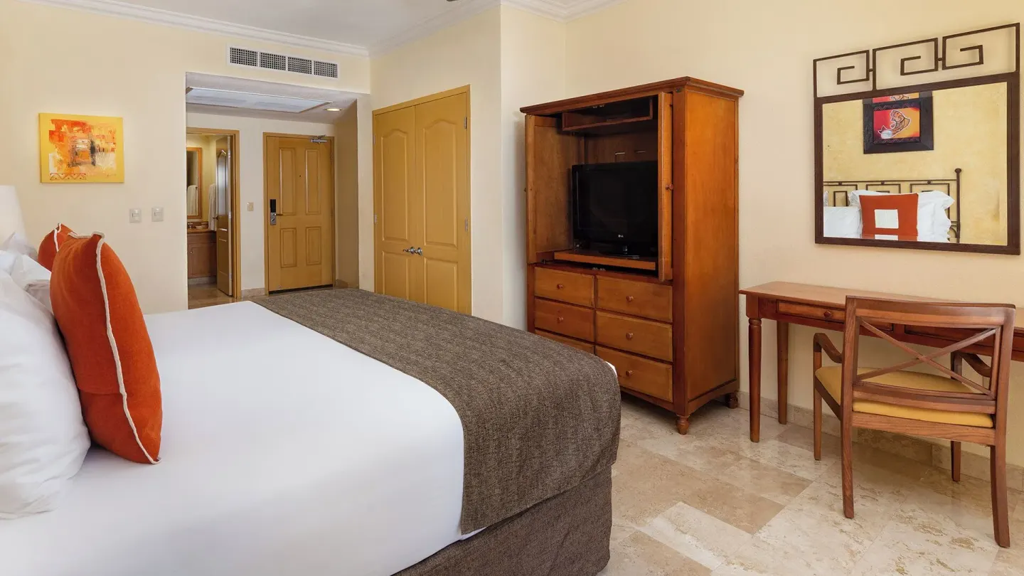 Deluxe Studio Garden View king bed, TV armoire and desk at Villa del Arco Beach Resort & Spa Cabo San Lucas.