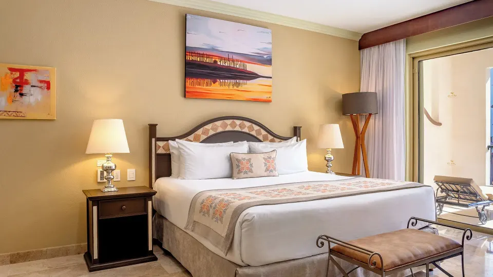 One Bedroom Suite Garden View king bed and balcony doors at Villa del Arco Beach Resort & Spa Cabo San Lucas.