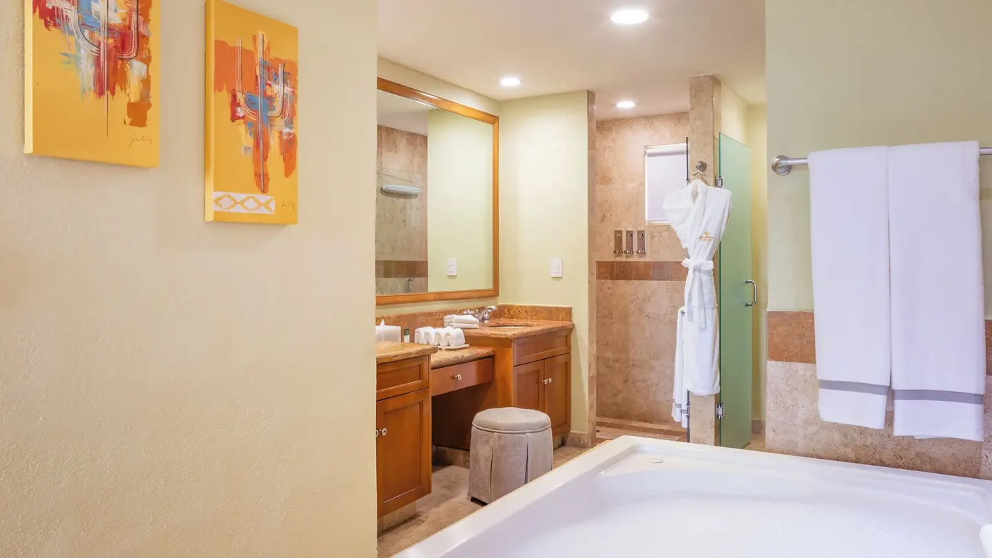 Two Bedroom Suite bathroom with tub, vanity, shower, and robe at Villa del Arco Beach Resort & Spa Cabo San Lucas.