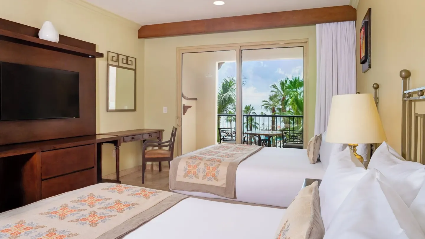 Two Bedroom Suite bedroom with balcony doors at Villa del Arco Beach Resort & Spa Cabo San Lucas.