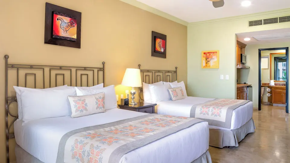 Two Bedroom Suite with two beds and bathroom doorway at Villa del Arco Beach Resort & Spa Cabo San Lucas.