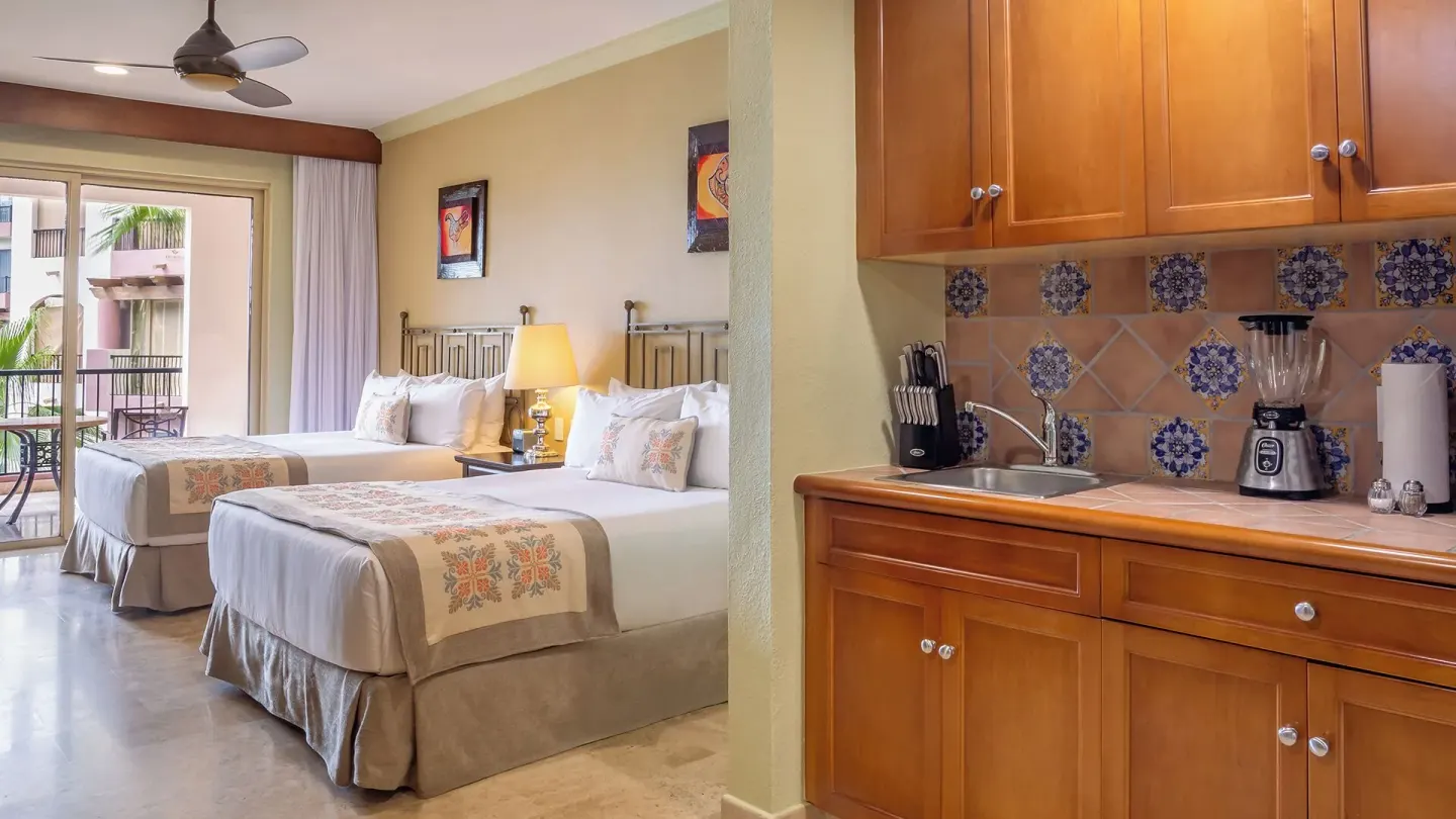 Two Bedroom Suite bedroom and kitchenette at Villa del Arco Beach Resort & Spa Cabo San Lucas.