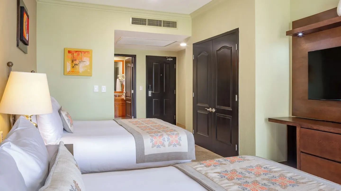 Two Bedroom Suite with two beds and TV at Villa del Arco Beach Resort & Spa Cabo San Lucas.