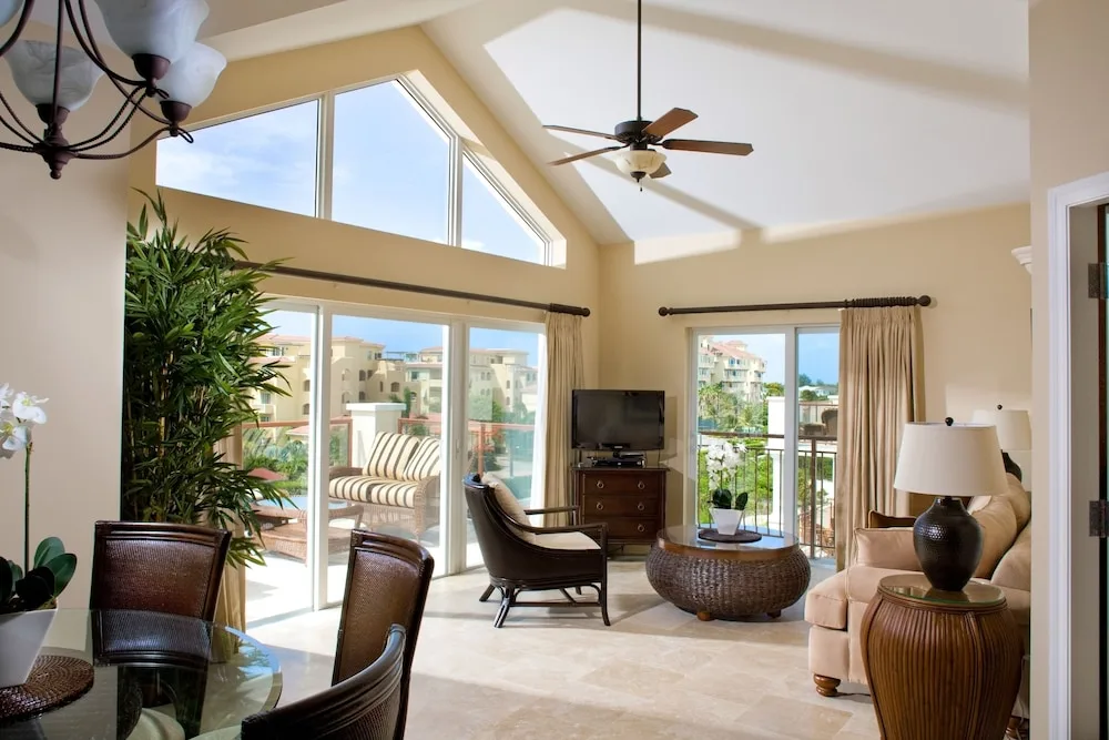 Bright living and dining area with vaulted ceiling and balcony doors at Villa del Mar.