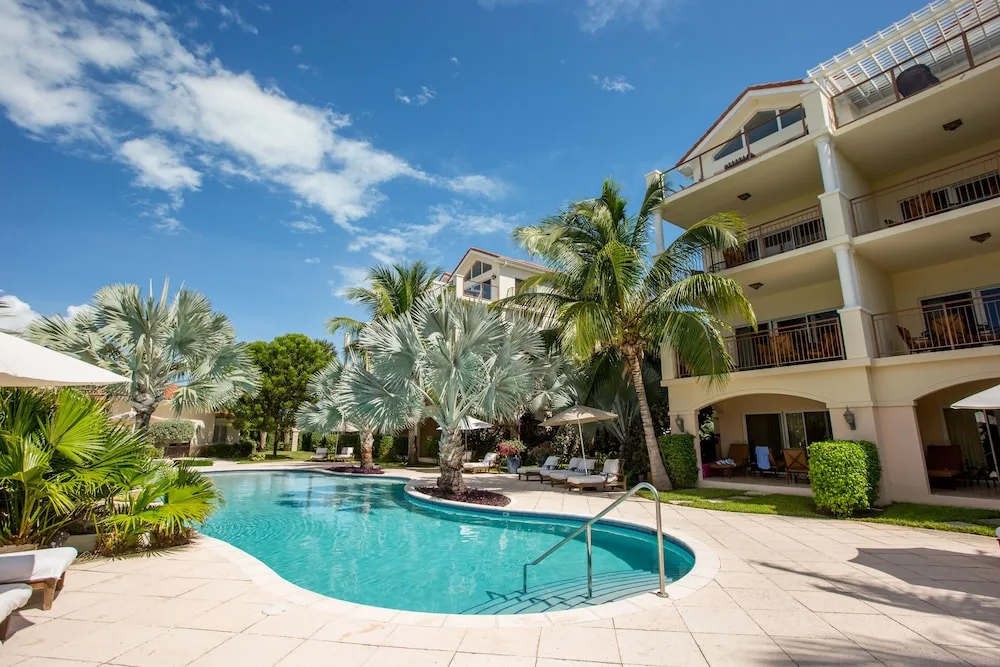 Curved swimming pool beside balconies and palm trees at Villa del Mar.