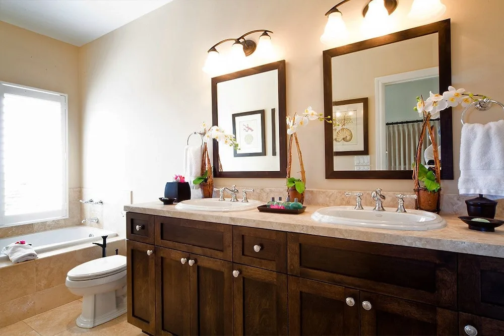 Large bathroom with double vanity, mirrors, bathtub, and toilet at Villa del Mar.