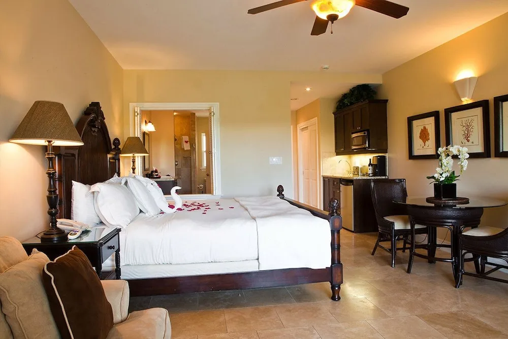 Guest room with canopy bed, kitchenette, and dining table at Villa del Mar.