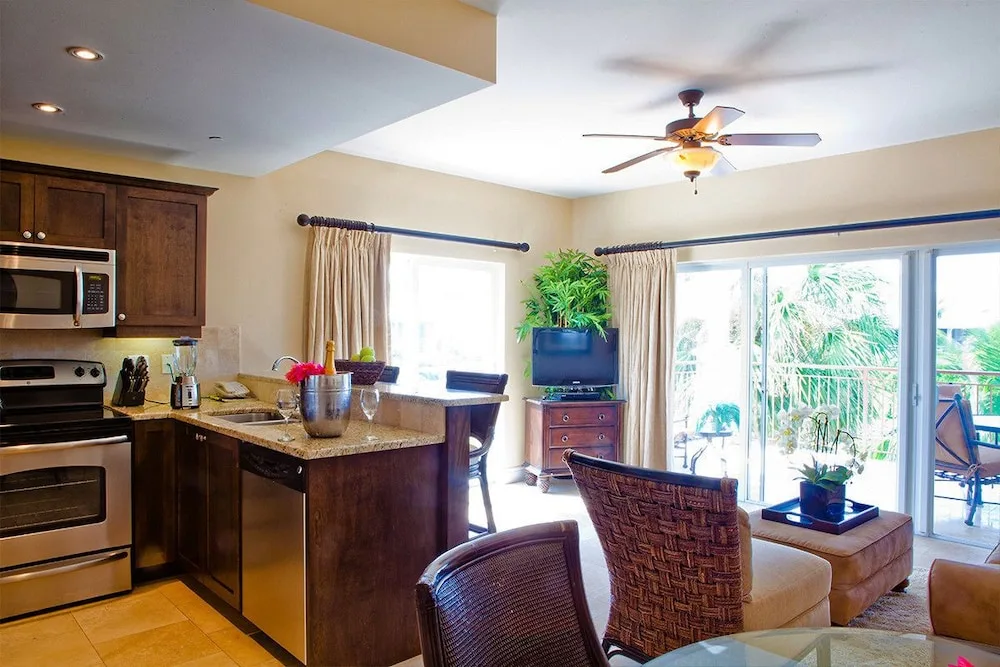 Kitchen and sitting area with balcony doors and ceiling fan at Villa del Mar.