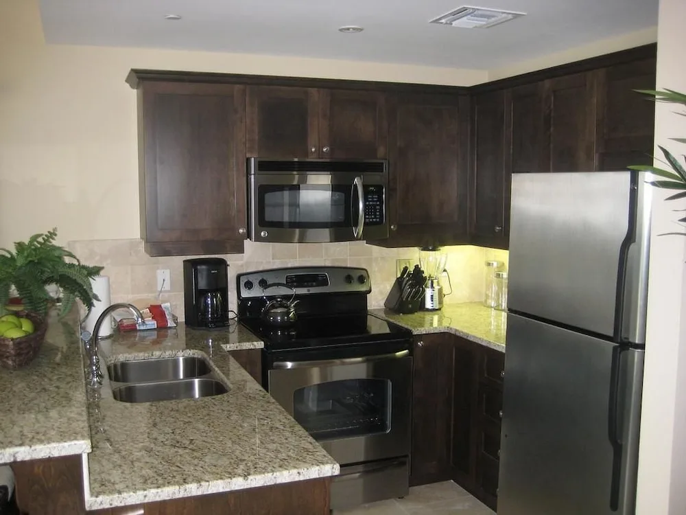 Compact suite kitchen with stainless appliances and granite counters at Villa del Mar.