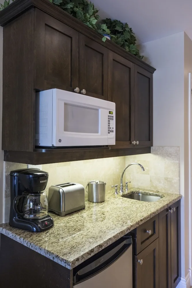 Suite kitchenette with granite counter, sink, microwave, and coffee maker at Villa del Mar.