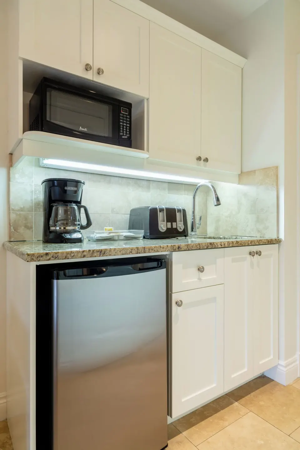 Deluxe Studio kitchenette with mini fridge, microwave, sink, coffee maker, and toaster at Villa del Mar.
